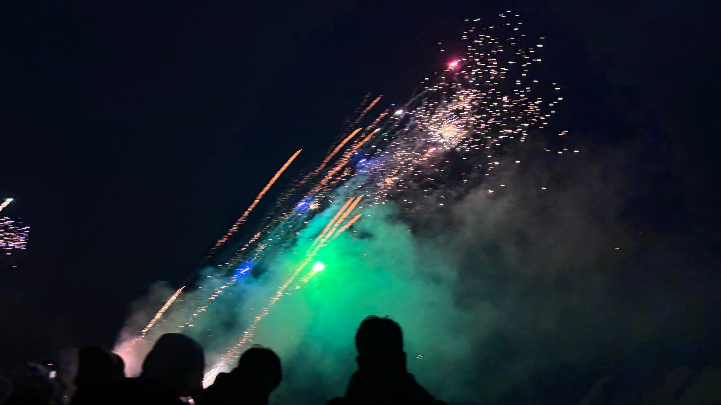 Gold and white fireworks bursting against a black night sky