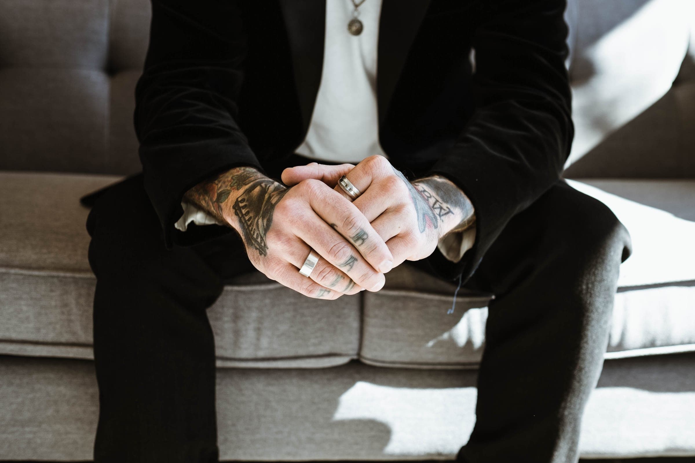 Close-up of a person's tattooed hands resting together